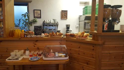 a bakery with bread and pastries on a counter at Hotel Glaizette in LʼArgentière-la-Bessée