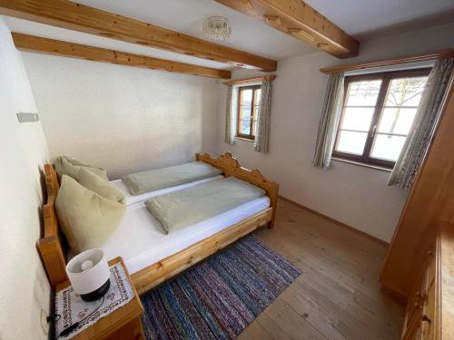 a bedroom with a wooden bed in a room with windows at Mantlerhof in Virgen
