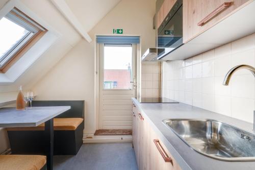 a kitchen with a sink and a window at Appartementen Parkzicht in Bergen aan Zee