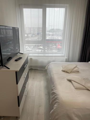a bedroom with a bed and a desk and a window at Happy apartment 1 in Roşu
