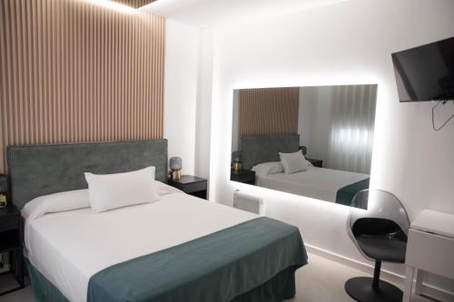 a hotel room with two beds and a mirror at M&A Hostal en Onda in Bechí