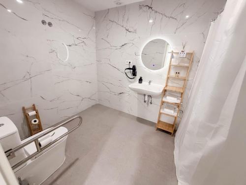 a white bathroom with a sink and a mirror at M&A Hostal en Onda in Bechí