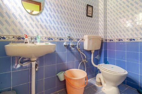 a blue tiled bathroom with a toilet and a sink at Forest View Penthouse Stay - PRIME HSR - Near NIFT in Bangalore