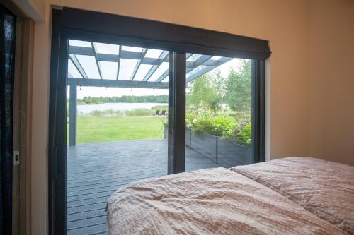 a bedroom with a large glass door to a patio at Laumiņas in Pavasari