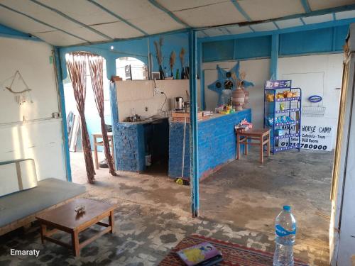 a room with a kitchen with blue walls at Hamata House Camp in Abū Ghuşūn
