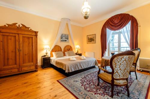 a bedroom with a bed and a chair and a window at Marcienas Muiza & SPA in Mārciena