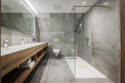 a bathroom with a shower and a sink and a toilet at Hotel Amselgrundschlößchen in Kurort Rathen