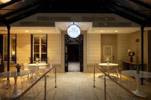 a restaurant with tables and a clock on the wall at Hotel Jean Moët in Épernay
