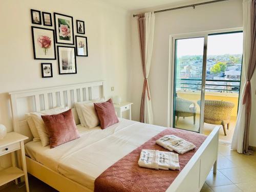 a bedroom with a large bed with a balcony at The Seashell Armação Beach Apartment in Armação de Pêra
