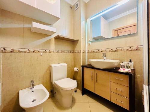 a bathroom with a toilet and a sink and a mirror at The Seashell Armação Beach Apartment in Armação de Pêra