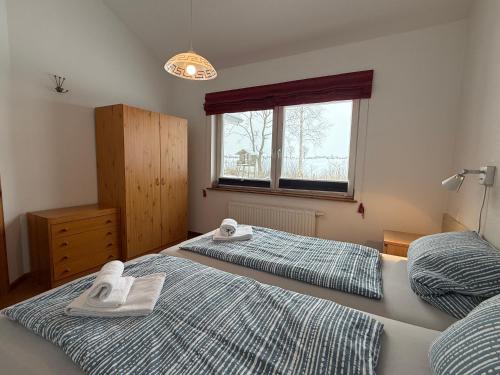 two beds in a bedroom with towels on them at Lachmöwe in Munkbrarup