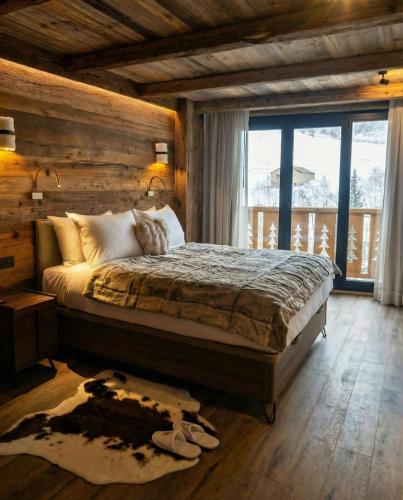 a bedroom with a bed and a large window at Hotel Vall d'Isard Suites in El Tarter