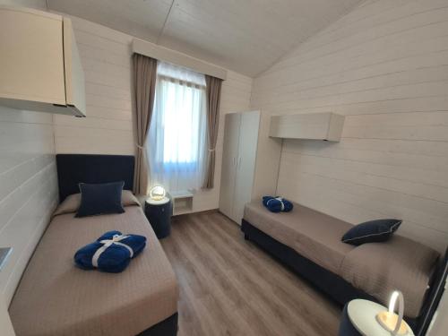 a bedroom with two beds with blue pillows on them at Residence Villalsole in San Felice del Benaco