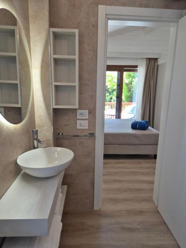 a bathroom with a sink and a bedroom with a bed at Residence Villalsole in San Felice del Benaco
