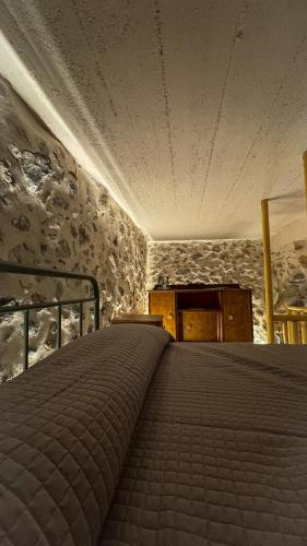 a bed in a room with a stone wall at Sadarmis Houses in Leonidio