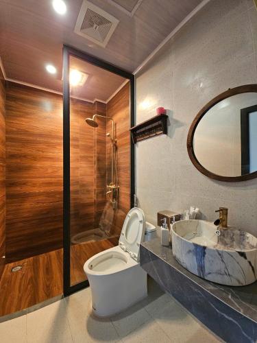 a bathroom with a sink and a toilet and a mirror at PiTu Homestay in Dồng Văn