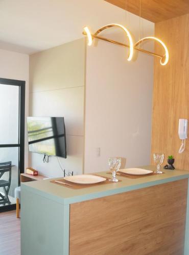 a room with a desk with a tv on a wall at Refugio Premium 2 Quartos 1 Suite WiFi Ar e Garagem in Pelotas