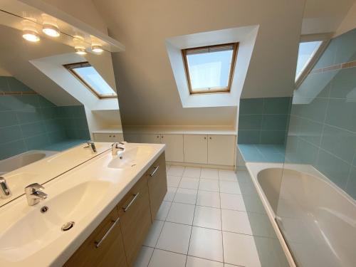 a bathroom with a sink and a bath tub at RIVAGE - Villa 6 pièces, Jardin, Calme - S28 in Carnac