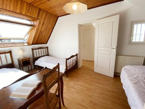 a room with two beds and a table and a window at VOILE D'ETAI - Maison, Calme, Jardin Clos - K343 in Carnac