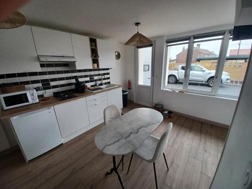 a kitchen with a table and chairs in a room at Le bon accueil in Coucy