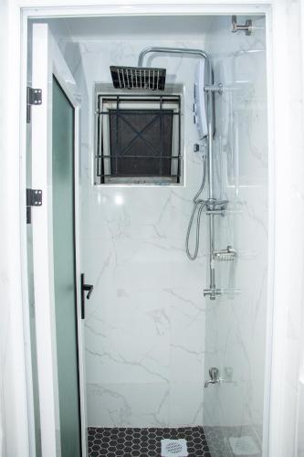 a bathroom with a shower with white marble at Cozy urban homes in Nakuru