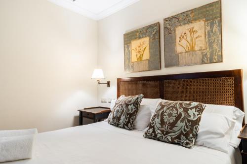 a bedroom with a white bed with two pillows at GAV Ciudad in Ronda