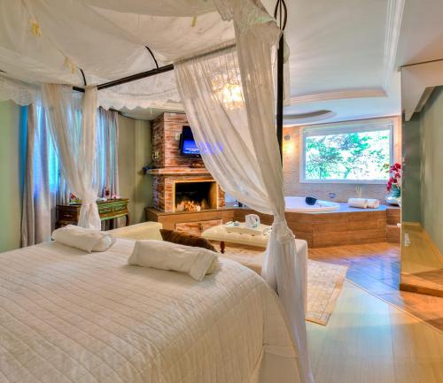 a bedroom with a large bed and a fireplace at La vanguardia by Don Ramon Hotel Boutique & Spa in Canela