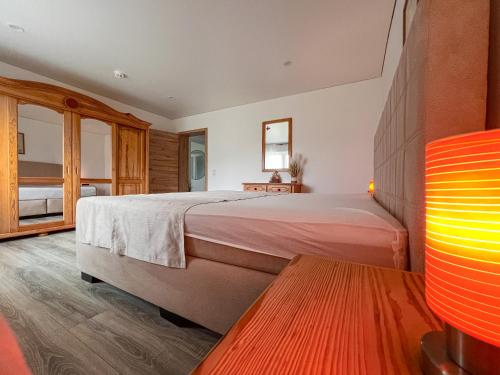 a bedroom with a large bed and a wooden floor at Talblick - Apartment Hortensie in Losheim