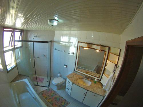 a bathroom with a sink and a toilet and a mirror at Sunhouse Hostel in Florianópolis