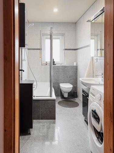 a bathroom with a tub and a toilet and a sink at Talblick - Apartment Hortensie in Losheim