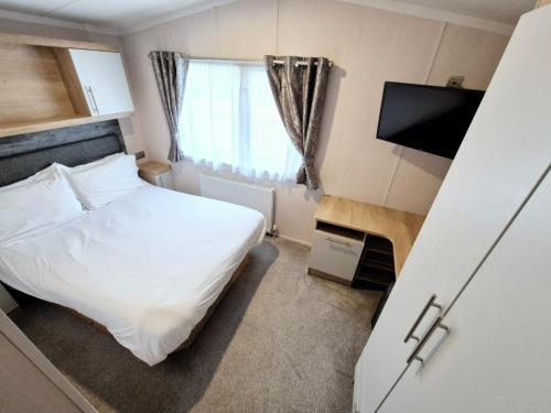 a small room with a bed and a television at Birchington Vale - Sleeps 8, Family friendly in Birchington