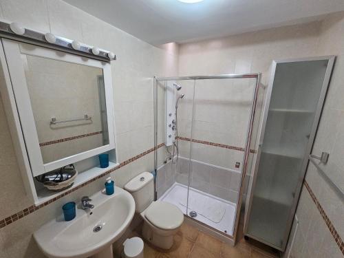 a bathroom with a shower and a toilet and a sink at Cuyagua in Corralejo