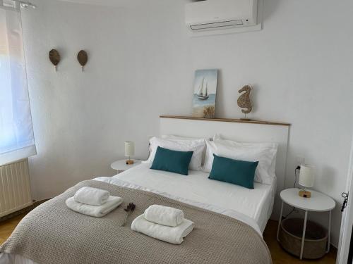 a bedroom with a large white bed with towels on it at Torre a Sant Martí d'Empúries in L'Escala