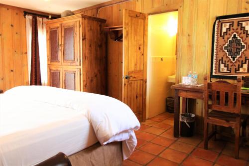 a bedroom with a bed and a desk and a chair at The Maverick Inn in Alpine