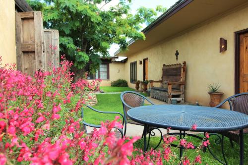 a patio with a table and chairs and pink flowers at The Maverick Inn in Alpine