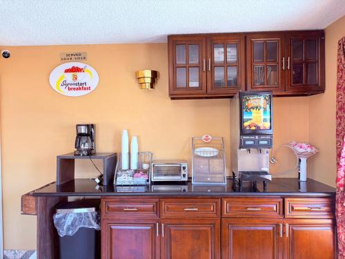 a kitchen with wooden cabinets and a counter top at Express Inn & Suites Houston Katy in Katy
