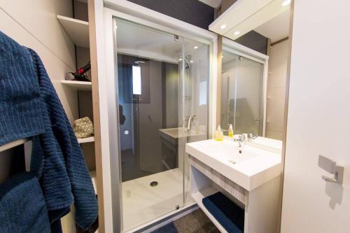 a bathroom with a shower and a white sink at Camping La Chapoulière in Ruoms