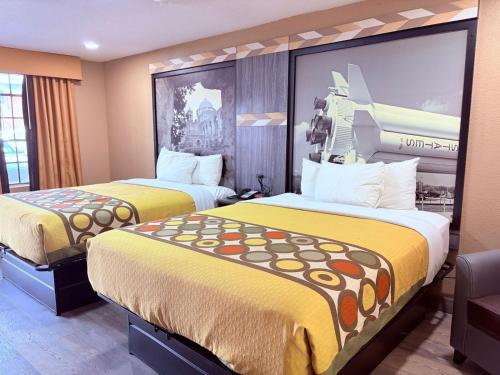 two beds in a hotel room with yellow beds at Express Inn & Suites Houston Katy in Katy