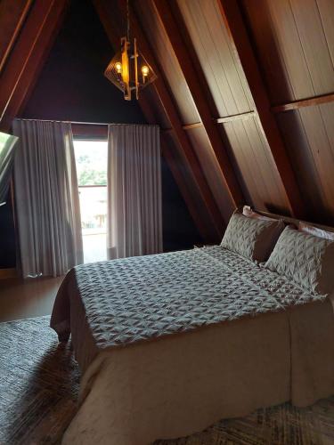 a bedroom with a bed with a wooden ceiling at Pousada Dona Bili in Pirenópolis