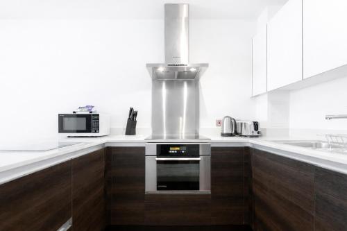 a kitchen with white counters and a stove top oven at Roomspace Serviced Apartments - Chorus in London