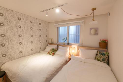 a bedroom with two beds and a window at 포레스트101 in Seoul