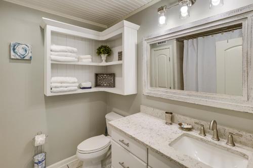a bathroom with a toilet and a sink and a mirror at Golf Course Views! Couple's Retreat in Diamondhead in Diamondhead