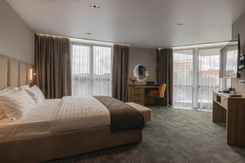 a hotel room with a bed and a desk and windows at Silver Apart in Truskavets