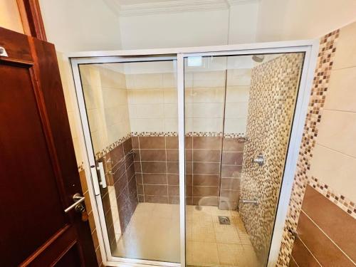 a shower with a glass door in a bathroom at JJ Comfort Homes in Arusha