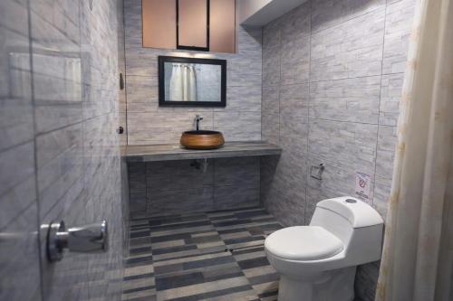 a bathroom with a white toilet and a sink at Mi Hacienda Pacucha in Andahuaylas