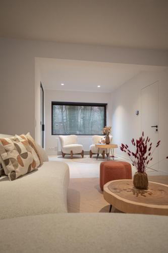 a living room with a white couch and a table at Stories Lodewijk en Margaretha in Bruges