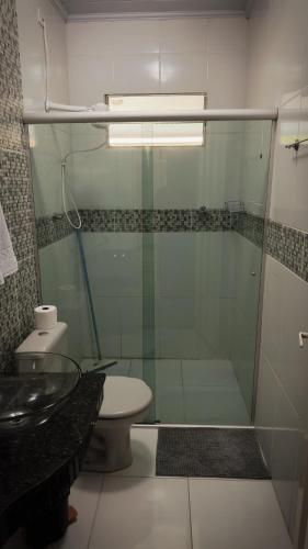 a bathroom with a glass shower and a toilet at Pousada Sítio Rupestre Peruaçu in Januária
