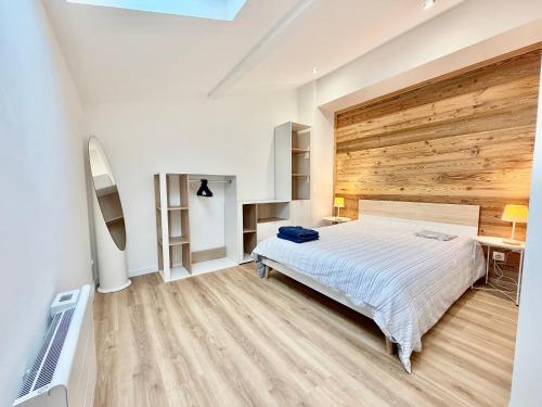 a bedroom with a bed and a wooden wall at Thyez rue des Acacias in Thyez