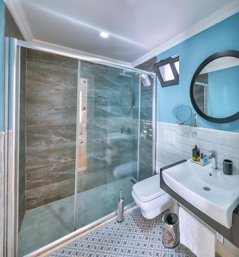 a bathroom with a shower and a toilet and a sink at Lale Hotel in Kaş