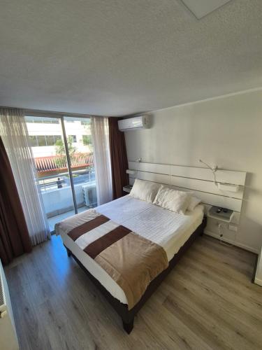 a bedroom with a bed and a large window at Apart Lyon Suite in Santiago